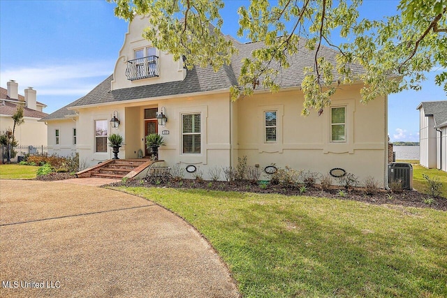 view of front of house with a porch, a front lawn, and central AC unit