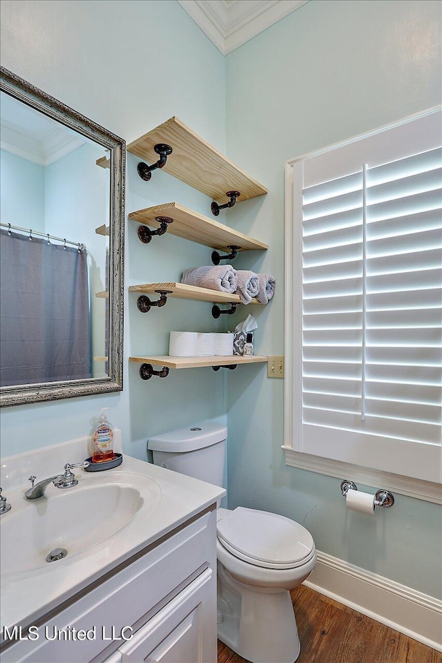 bathroom featuring wood finished floors, vanity, toilet, and ornamental molding