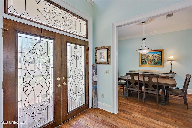 entrance foyer featuring ornamental molding, french doors, and wood-type flooring