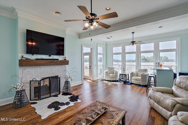 living room with crown molding, dark wood-type flooring, a fireplace, and ceiling fan