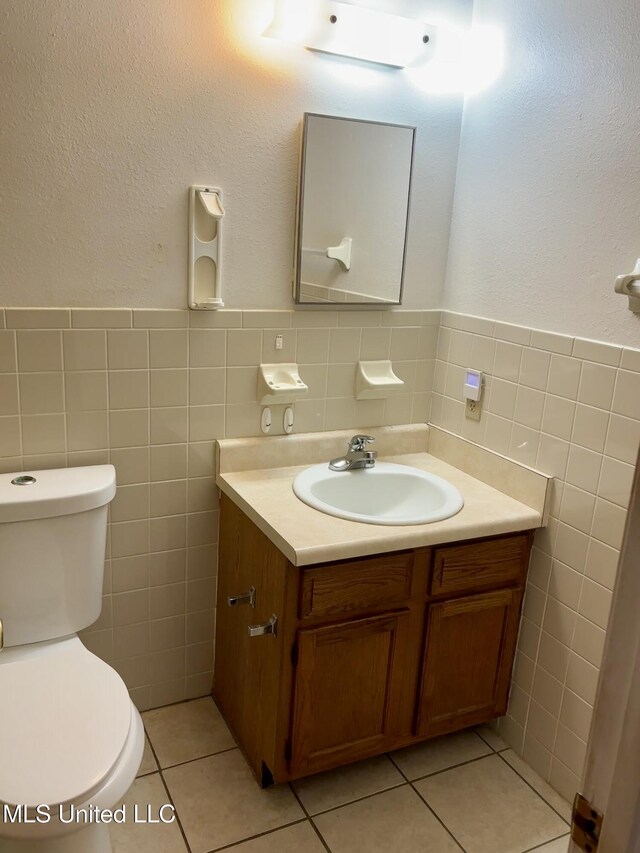126 Faust Dr, Gulfport, MS 39503 - half bath with tile walls, vanity, toilet, tile patterned flooring, and a wainscoted wall
