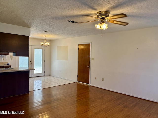 126 Faust Dr, Gulfport, MS 39503 - unfurnished living room with a chandelier, light wood-style floors, ceiling fan, a textured ceiling, and baseboards