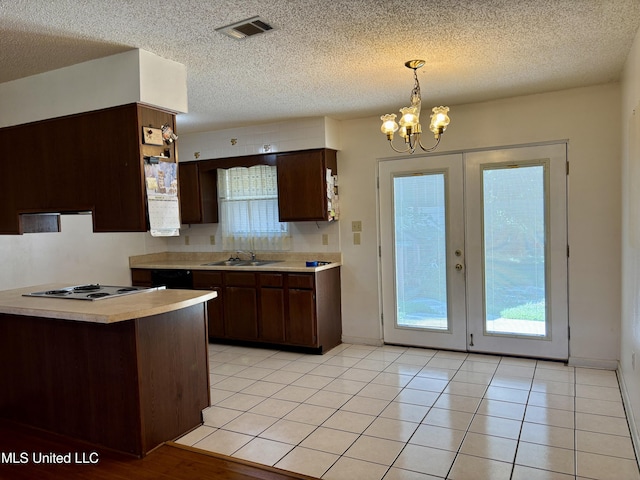 126 Faust Dr, Gulfport, MS 39503 - kitchen with a sink, cooktop, light countertops, a chandelier, and dark brown cabinets