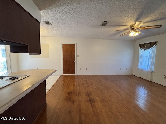 126 Faust Dr, Gulfport, MS 39503 - kitchen featuring a ceiling fan, wood finished floors, a textured ceiling, electric stovetop, and dark brown cabinetry