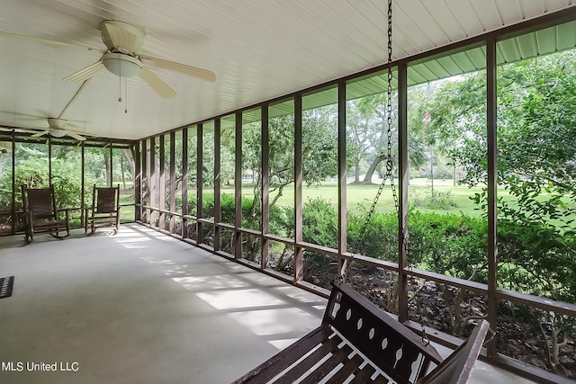 unfurnished sunroom featuring ceiling fan