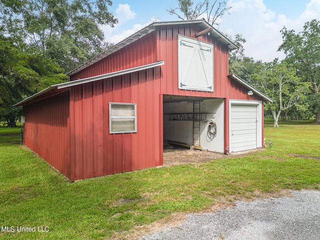 view of outbuilding featuring a garage and a lawn