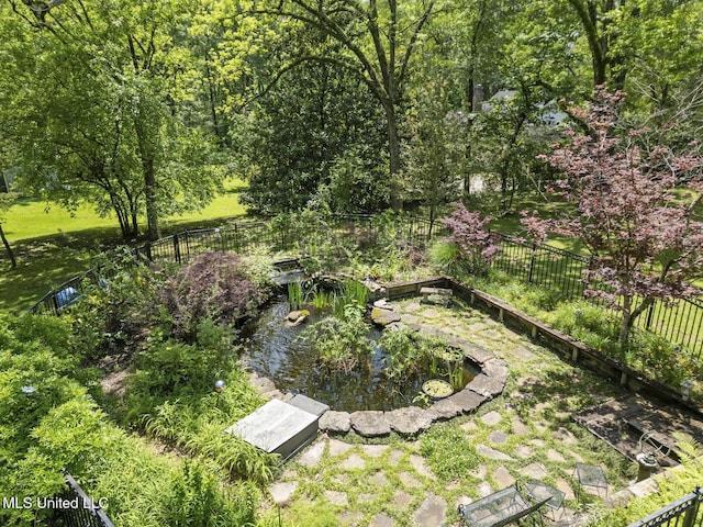 315 N St, Lexington, MS 39095 - view of yard featuring fence, a garden, and a garden pond