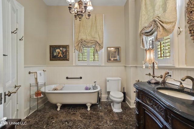 315 N St, Lexington, MS 39095 - full bathroom with vanity, toilet, wainscoting, and a freestanding tub