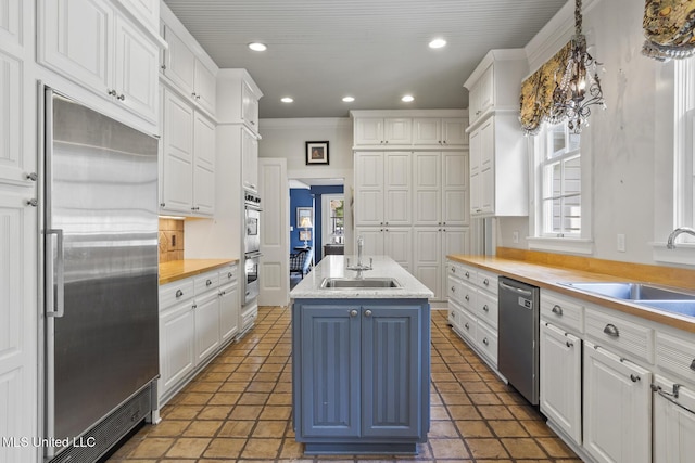 315 N St, Lexington, MS 39095 - kitchen featuring white cabinets, stainless steel appliances, an island with sink, and a sink