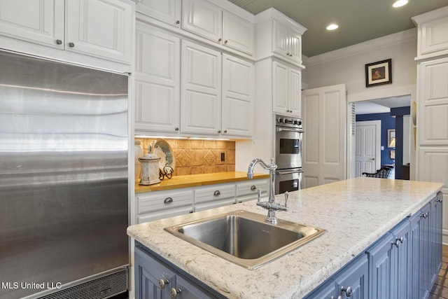 315 N St, Lexington, MS 39095 - kitchen featuring a sink, white cabinetry, appliances with stainless steel finishes, blue cabinets, and recessed lighting