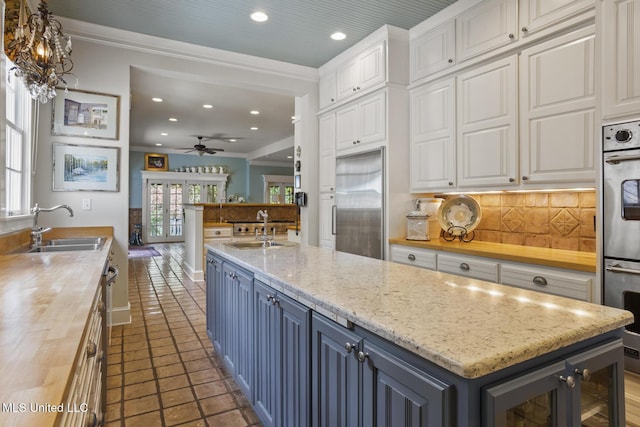 315 N St, Lexington, MS 39095 - kitchen featuring a sink, stainless steel appliances, backsplash, and white cabinets