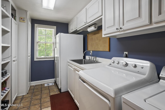 315 N St, Lexington, MS 39095 - laundry room featuring stone finish flooring, a sink, cabinet space, washing machine and clothes dryer, and visible vents