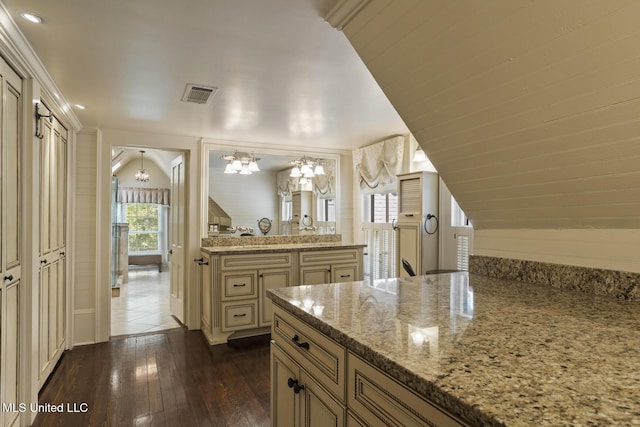 315 N St, Lexington, MS 39095 - kitchen with light stone counters, dark wood-type flooring, visible vents, an inviting chandelier, and cream cabinetry