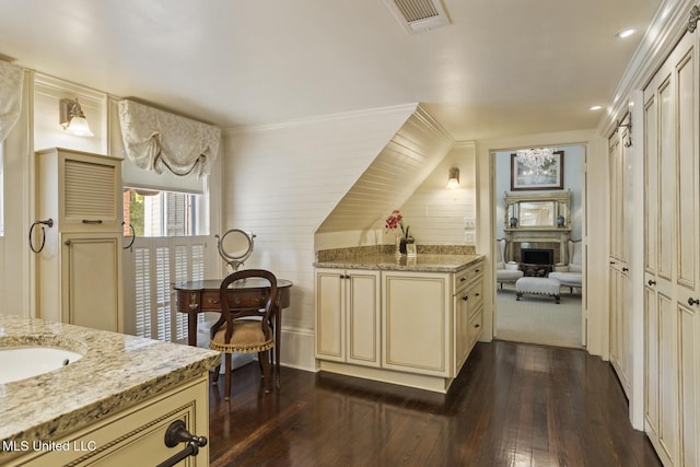 315 N St, Lexington, MS 39095 - kitchen with a sink, visible vents, dark wood finished floors, cream cabinetry, and light stone countertops