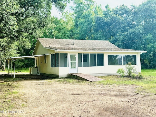 view of front of home with a sunroom and a carport