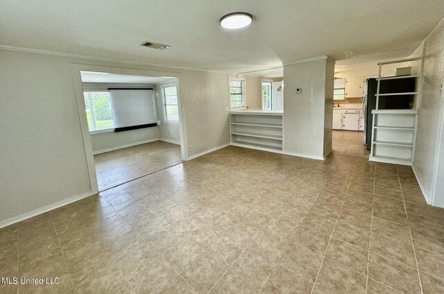 empty room with ornamental molding and a wealth of natural light