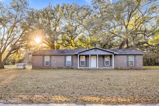 ranch-style home featuring a front lawn and covered porch