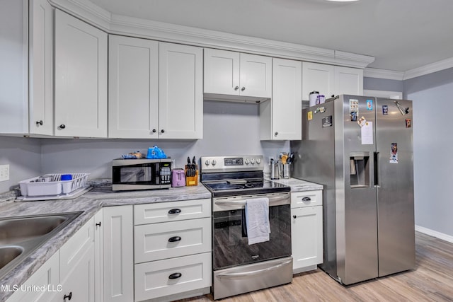 kitchen with white cabinetry, stainless steel appliances, sink, ornamental molding, and light wood-type flooring