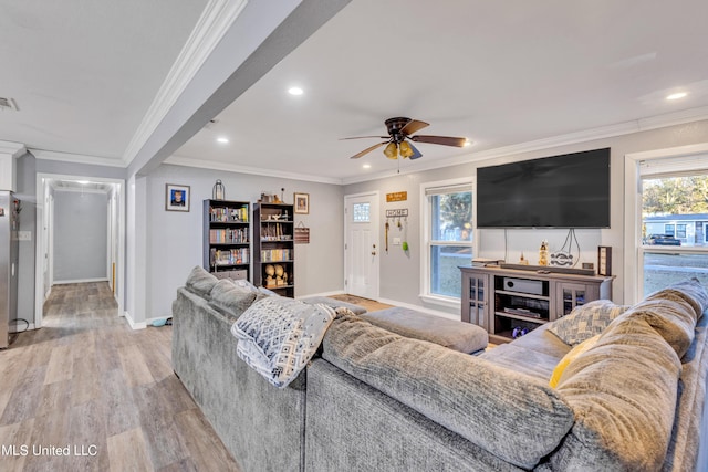 living room with ceiling fan, ornamental molding, and light hardwood / wood-style flooring