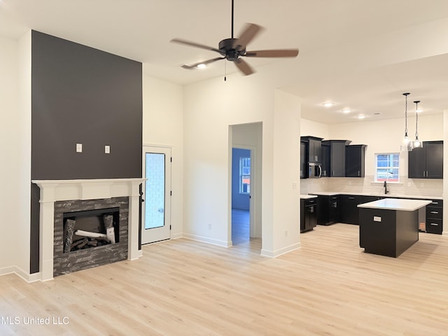 3165 Winterwood Dr, Hernando, MS 38632 - kitchen featuring stainless steel microwave, a kitchen island, open floor plan, light countertops, and dark cabinets