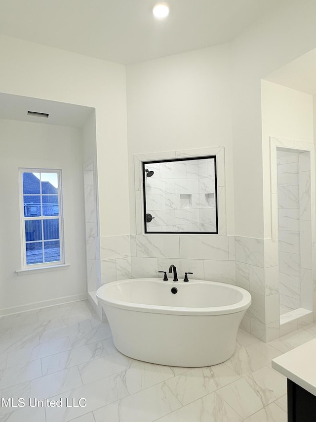 3165 Winterwood Dr, Hernando, MS 38632 - full bathroom with a soaking tub, marble finish floor, tile walls, and visible vents