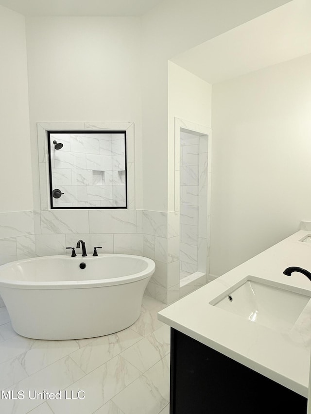 3165 Winterwood Dr, Hernando, MS 38632 - bathroom with a freestanding tub, marble finish floor, a sink, tile walls, and double vanity