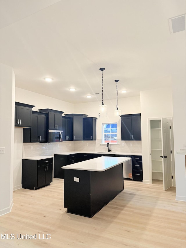 3165 Winterwood Dr, Hernando, MS 38632 - kitchen with backsplash, a kitchen island, and light wood-style floors