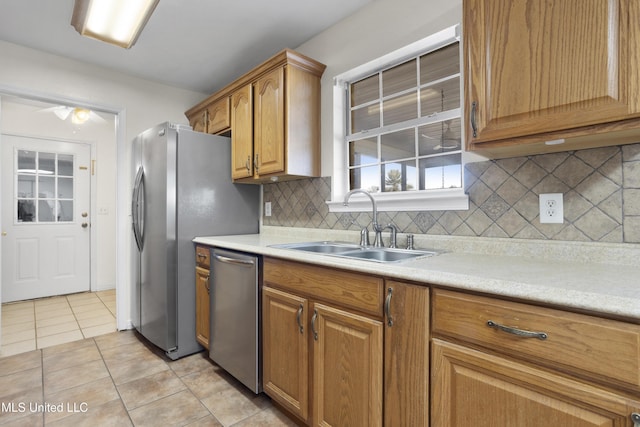 kitchen featuring light tile patterned flooring, stainless steel appliances, sink, and tasteful backsplash