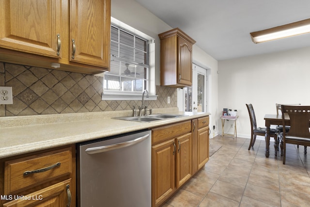 kitchen featuring light tile patterned floors, dishwasher, sink, and backsplash