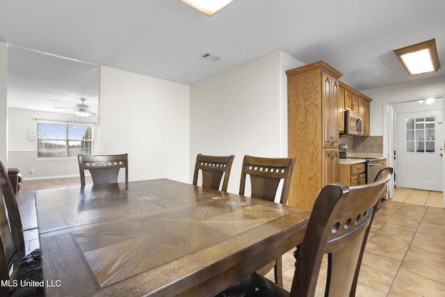 tiled dining room featuring ceiling fan