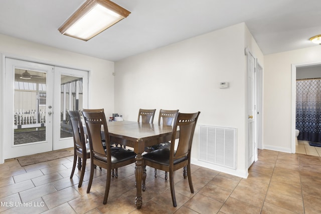 tiled dining space featuring french doors