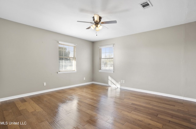 unfurnished room featuring dark wood-type flooring and ceiling fan