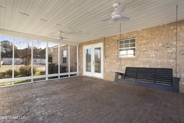 unfurnished sunroom with ceiling fan