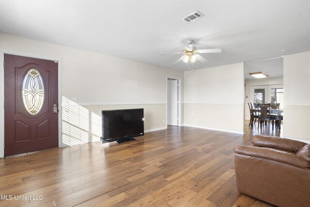 living room featuring wood-type flooring and ceiling fan