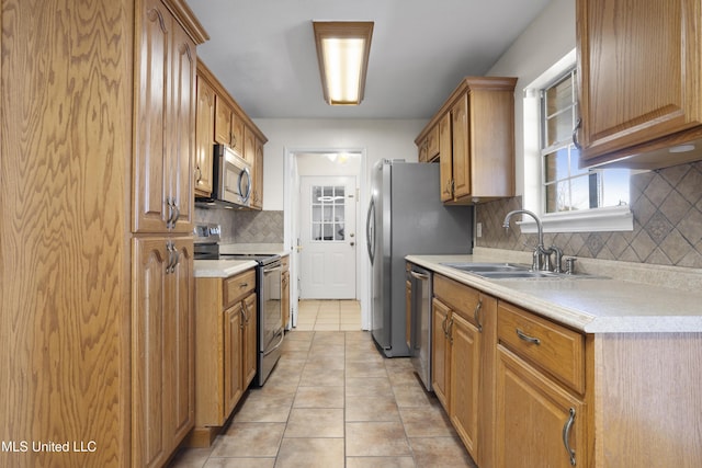 kitchen with light tile patterned flooring, stainless steel appliances, sink, and decorative backsplash