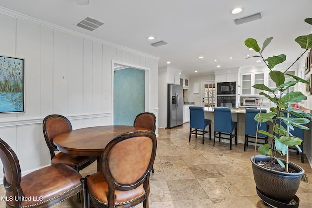 dining space featuring recessed lighting, visible vents, crown molding, and a decorative wall