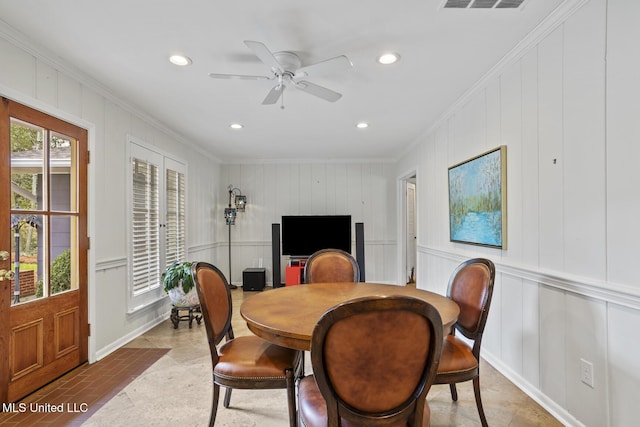 dining space featuring recessed lighting, a healthy amount of sunlight, crown molding, and a decorative wall