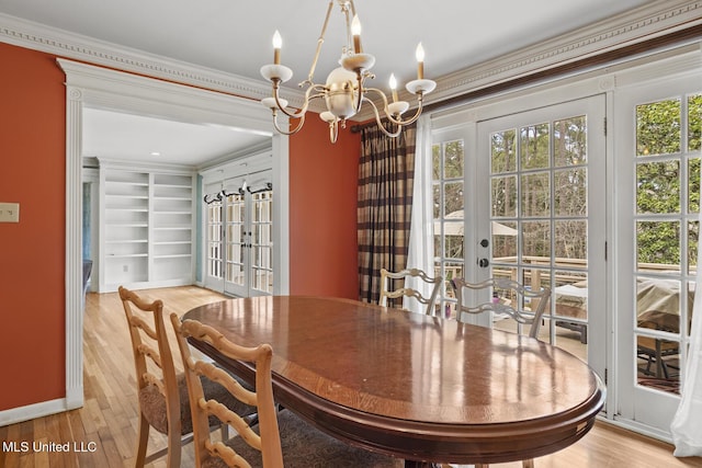 dining area featuring french doors, a healthy amount of sunlight, light wood-style flooring, and crown molding