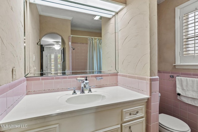 bathroom with curtained shower, toilet, tile walls, vanity, and ornamental molding