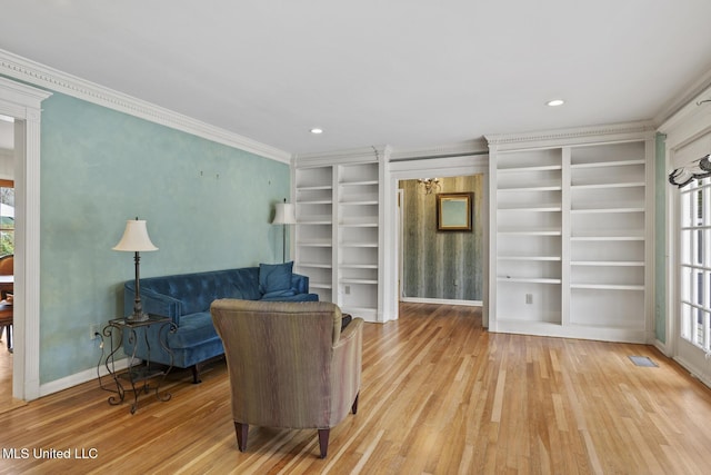 living area featuring light wood-style flooring, visible vents, built in features, baseboards, and ornamental molding