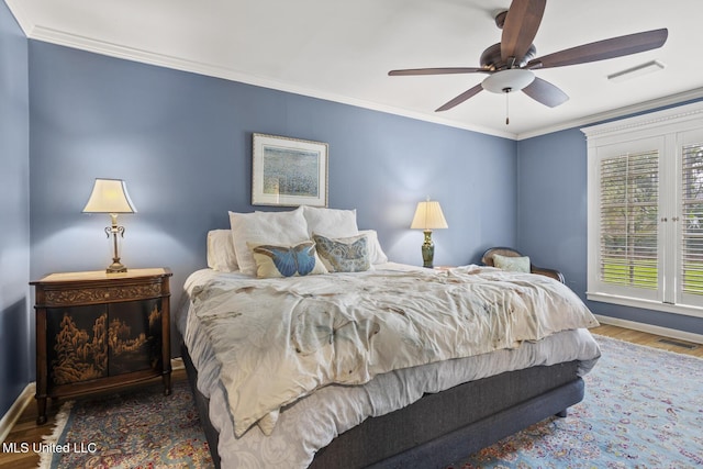 bedroom featuring ornamental molding, visible vents, ceiling fan, and wood finished floors