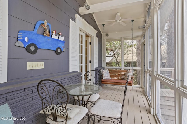 sunroom / solarium featuring ceiling fan and beamed ceiling