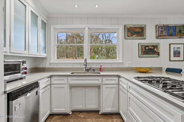 kitchen with dishwasher, light countertops, a sink, and white cabinetry