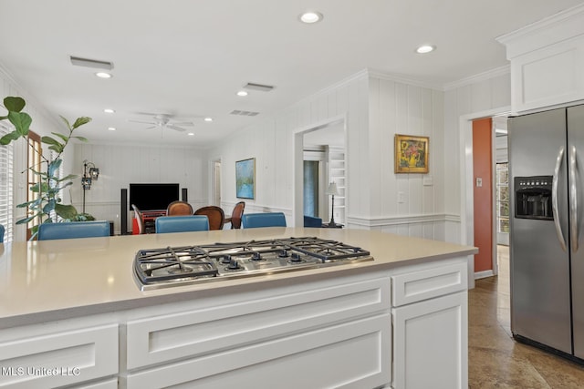 kitchen with stainless steel appliances, light countertops, and white cabinetry