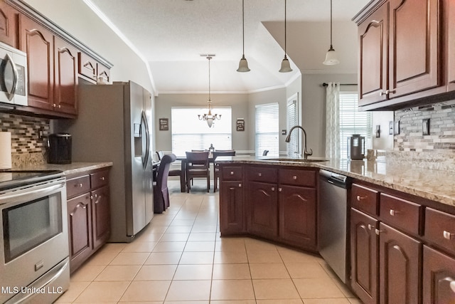 kitchen with sink, appliances with stainless steel finishes, tasteful backsplash, an inviting chandelier, and hanging light fixtures