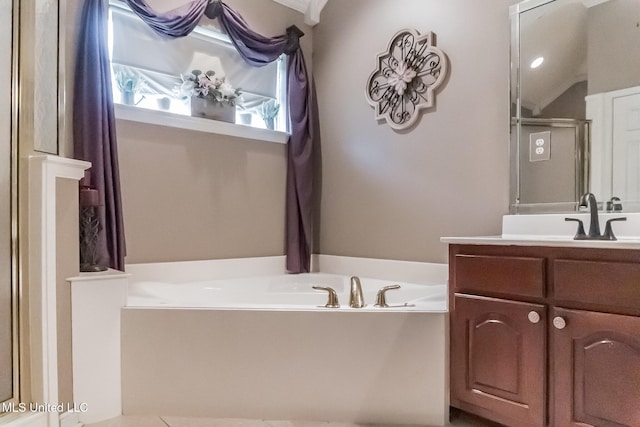 bathroom featuring shower with separate bathtub and vanity