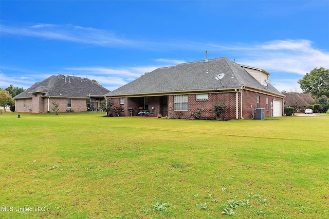 back of house with central AC unit, a garage, and a lawn