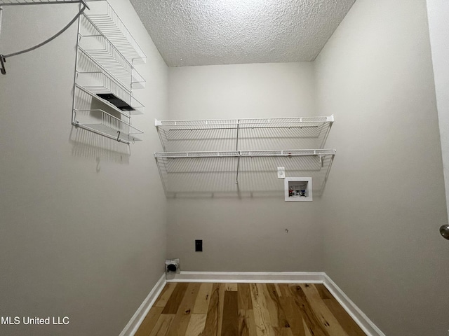 laundry area featuring laundry area, wood finished floors, baseboards, electric dryer hookup, and washer hookup