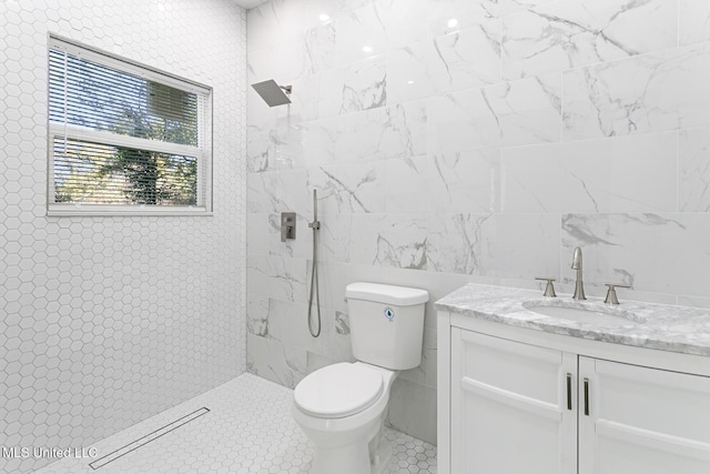 bathroom featuring tiled shower, vanity, toilet, and tile patterned flooring