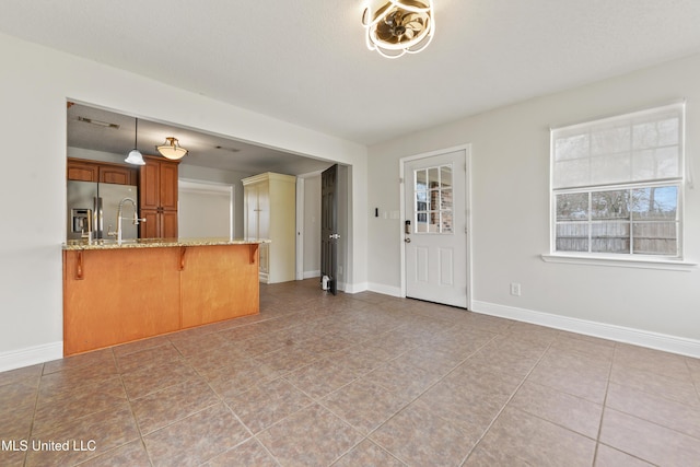 unfurnished living room with baseboards and light tile patterned floors